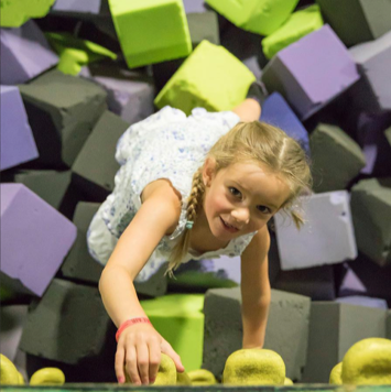 Child playing in a foam pit or landing zone at Get Air Rapid City