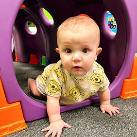 Young child crawling through a play tunnel at GO WILD! Family Fun Zone.