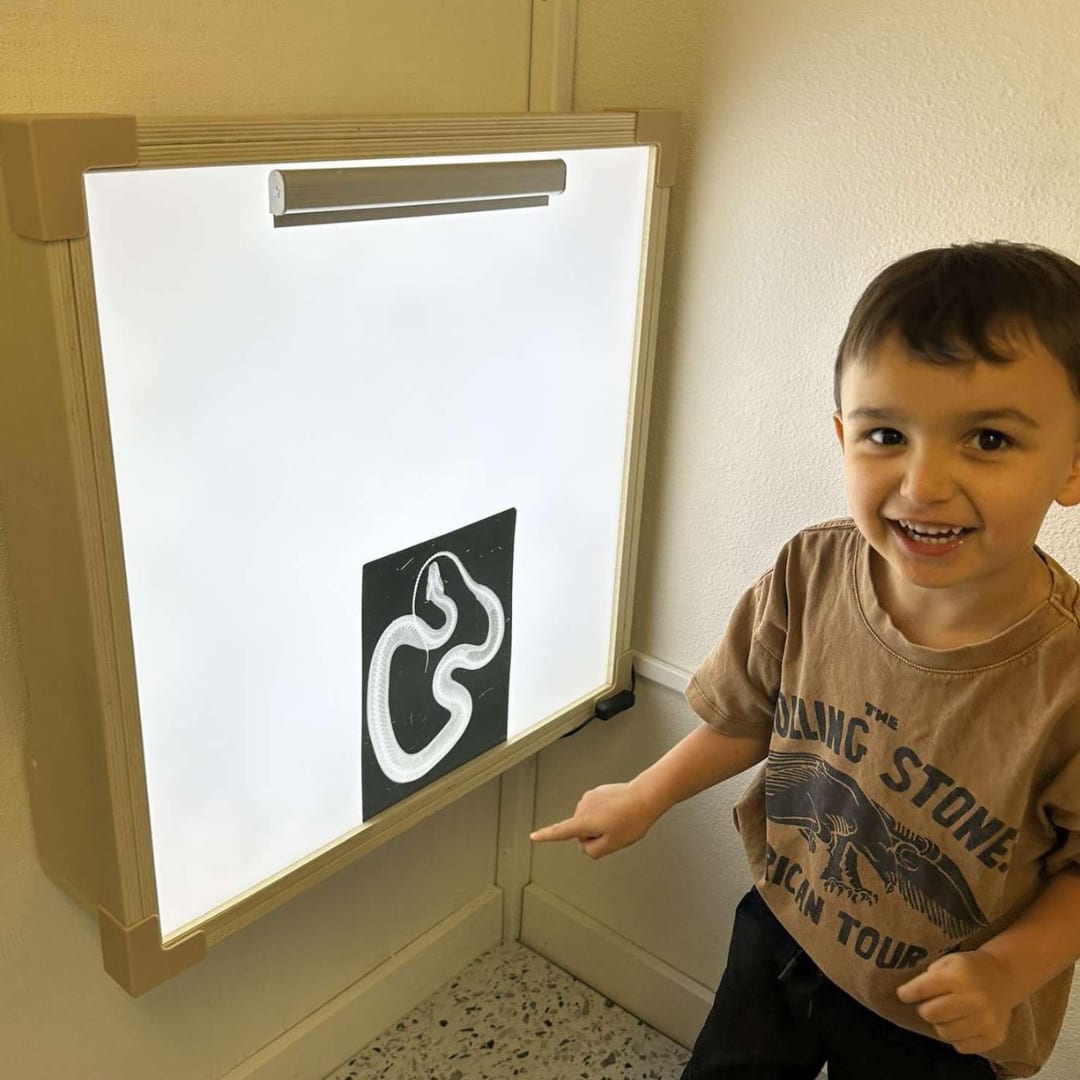 Child using an x-ray style light board at Goose & Rev Play Co. in Ellensburg.