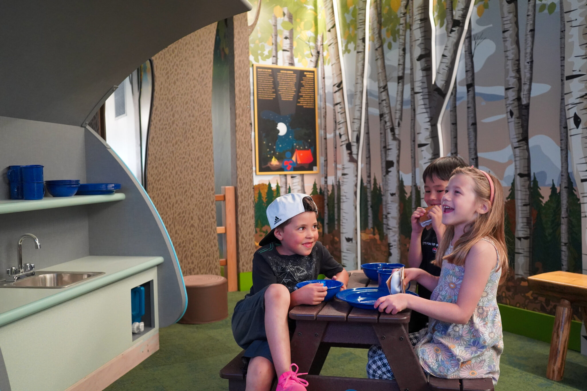 Children using a pretend dining and role-play exhibit at Great River Children's Museum.