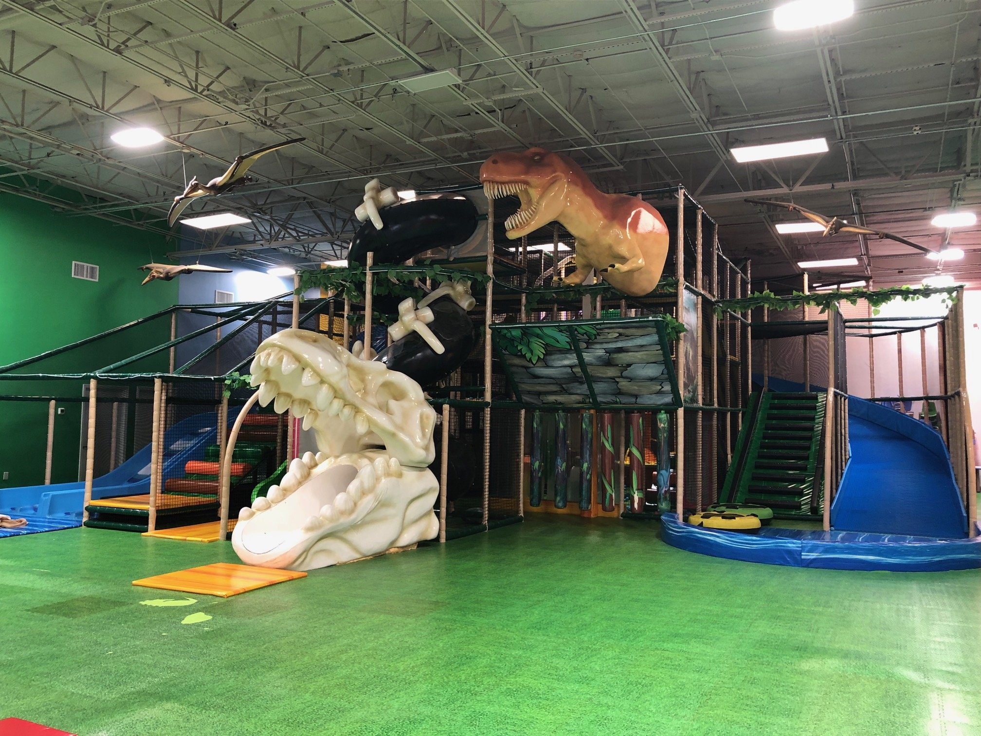 Large dinosaur-themed soft-play climber at Happy Land