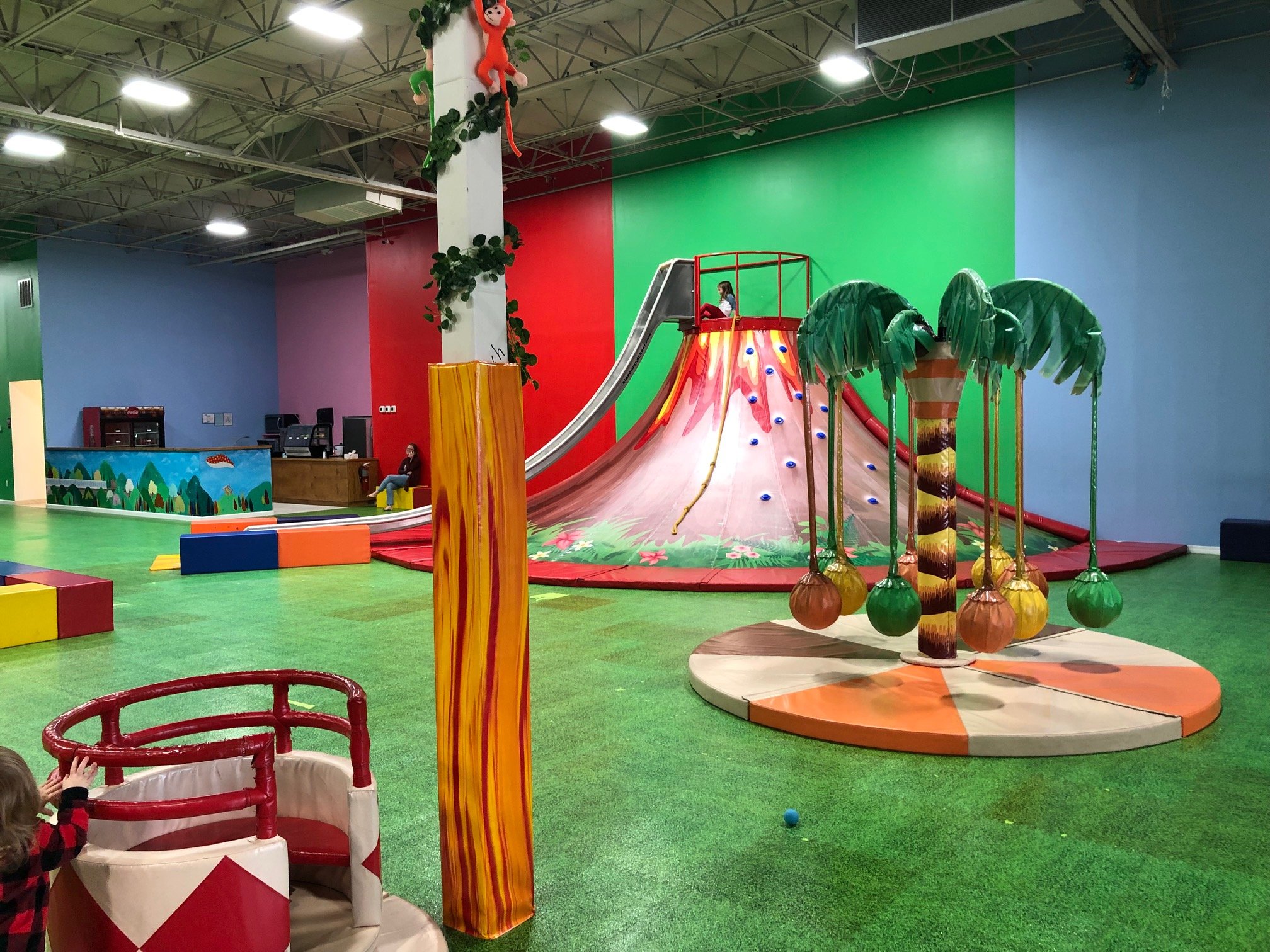 Volcano slide and open turf play area at Happy Land Indoor Playground