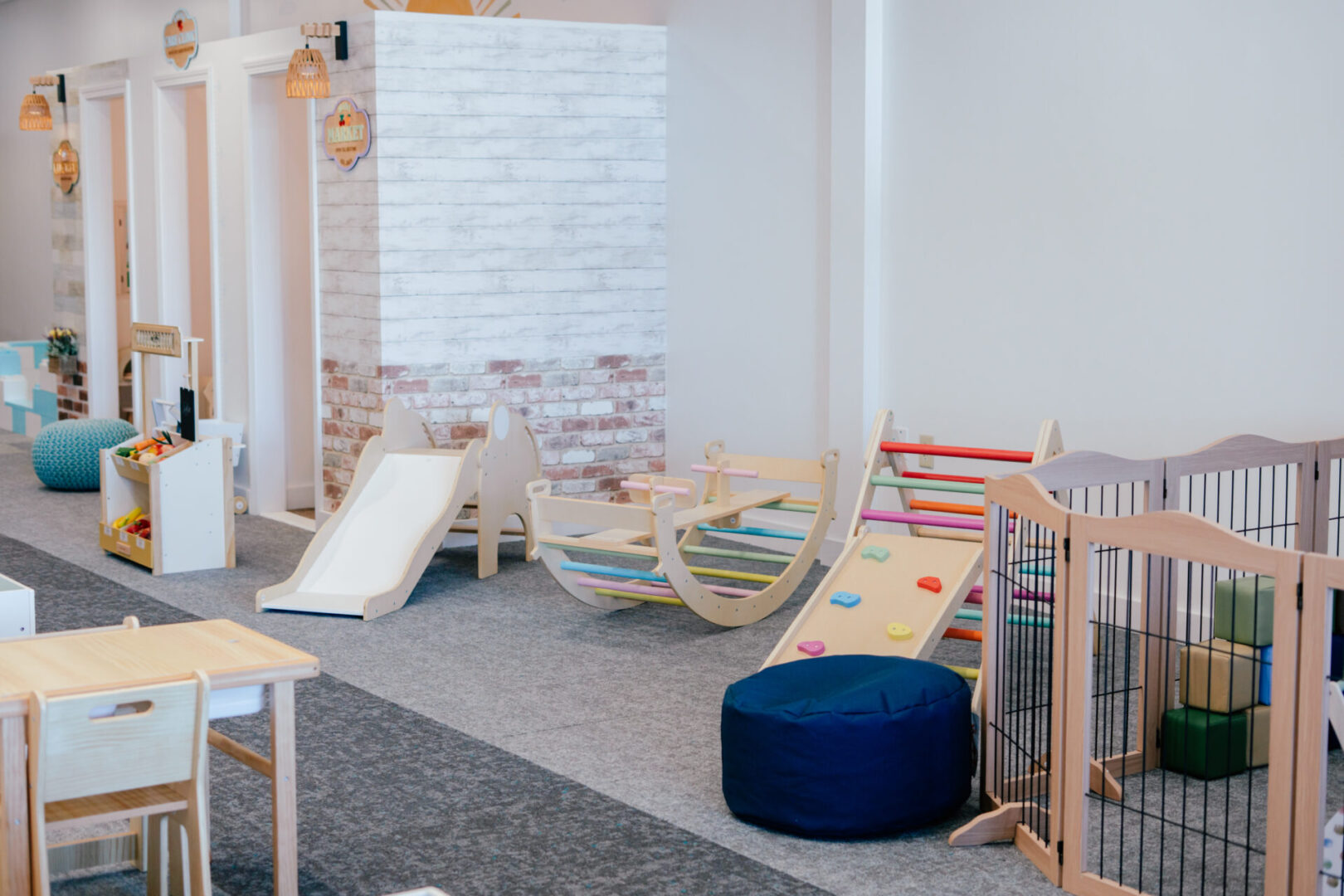 Small slide and toddler climbing elements inside Happy Play Day.