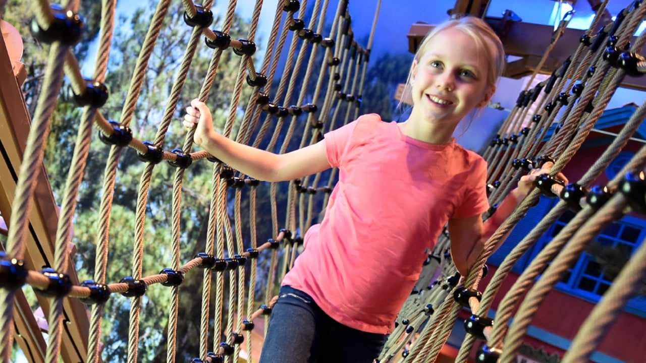 Child on rope bridges at Howler's Peak Adventure Trail.