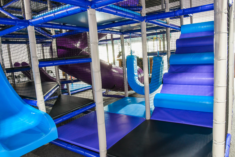 Children's indoor play area with bright padded structures and slide elements at InPlay! Family Fun.