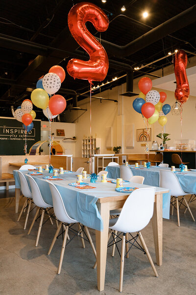 Party tables and cafe-style seating inside Inspired Play Cafe.