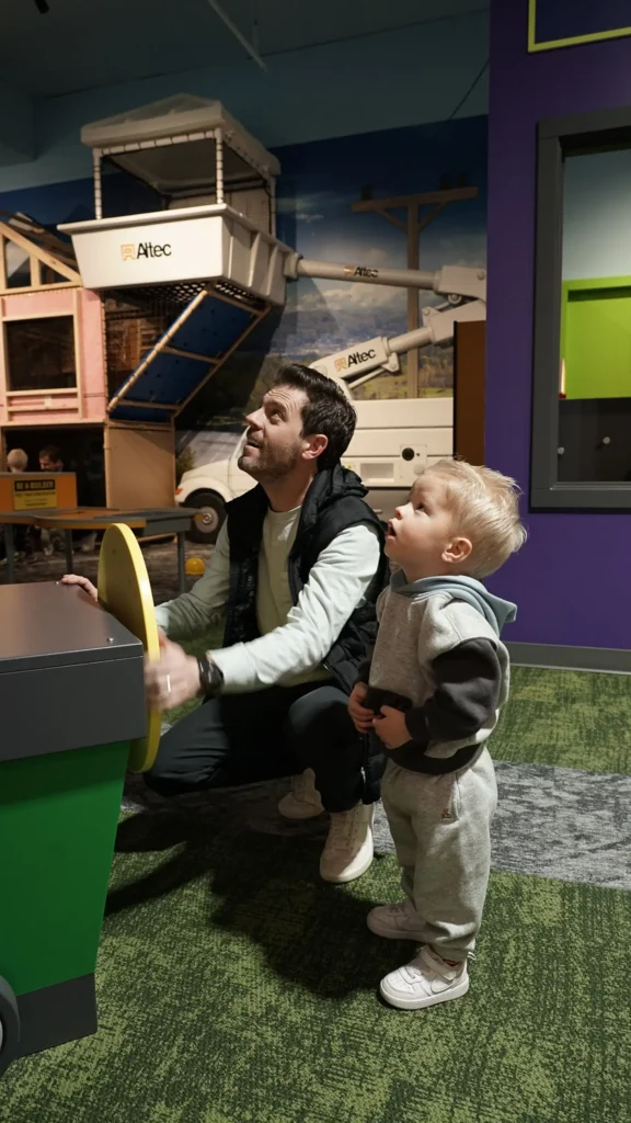 Child and caregiver interacting with a hands-on exhibit at inspireU