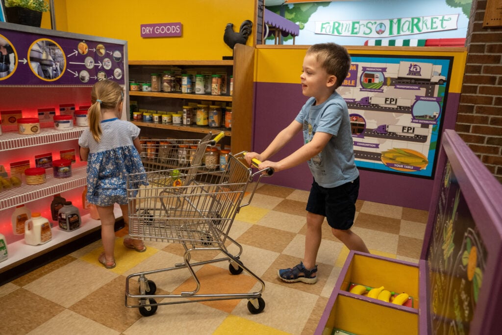 Children shopping in the City Grocery exhibit