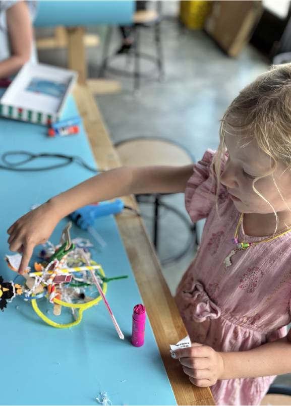 Child making a craft at a work table inside Jackson Hole Children's Museum.