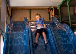 Child riding a double slide at Jungle Gym's in Grangeville.