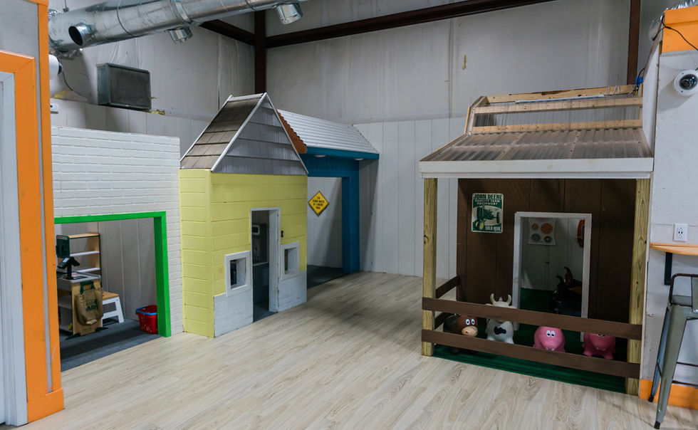 Pretend-play town area with child-sized buildings for younger children at Kid Zone.