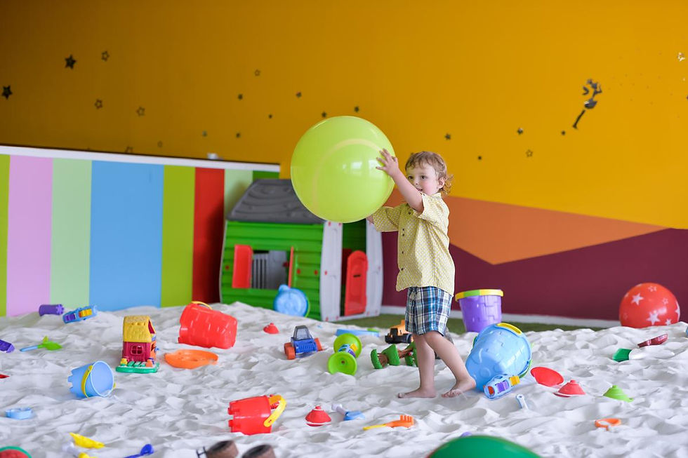 Child playing in the indoor sandbox at Kiddy Club