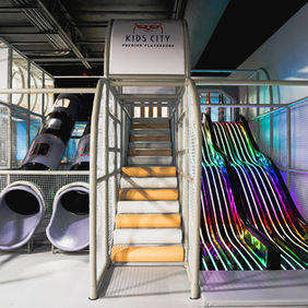 Rainbow multi-lane slide setup inside Kids City Kapolei