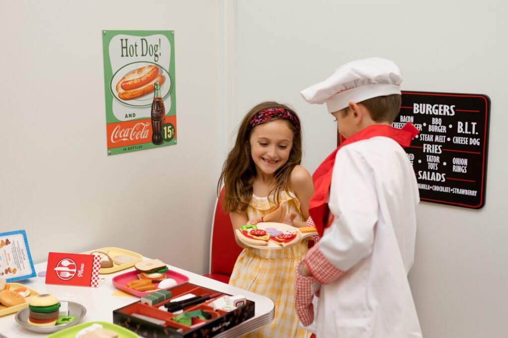 Children using the diner pretend-play station at Kids Hideout.