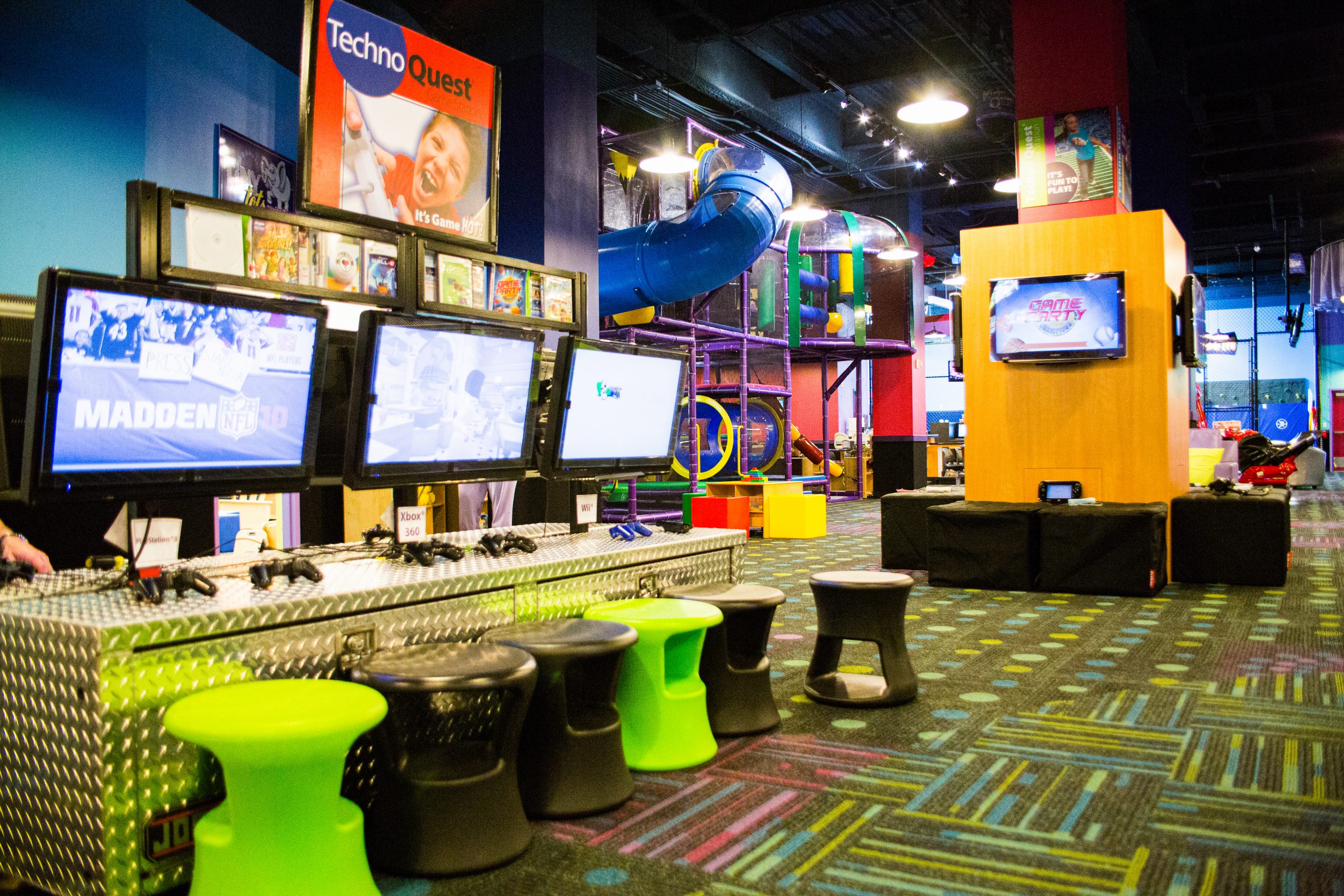 Main Kids Quest play floor with screens, seating, and a large indoor climbing structure.