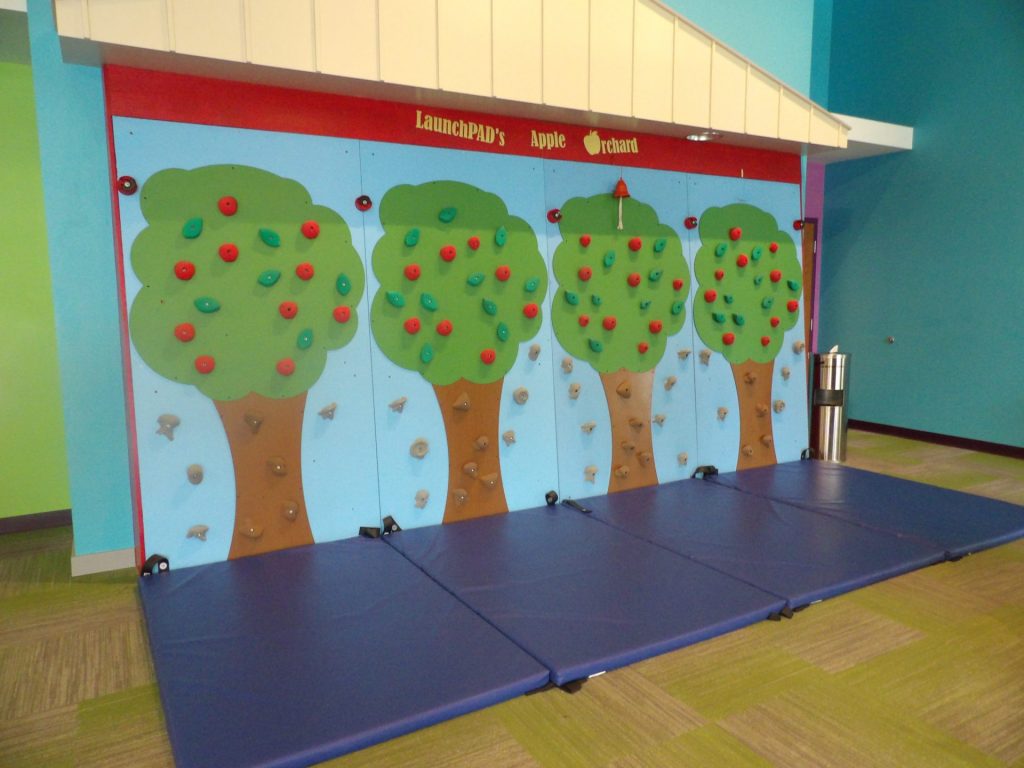 Apple orchard themed climbing wall at LaunchPAD Children's Museum.