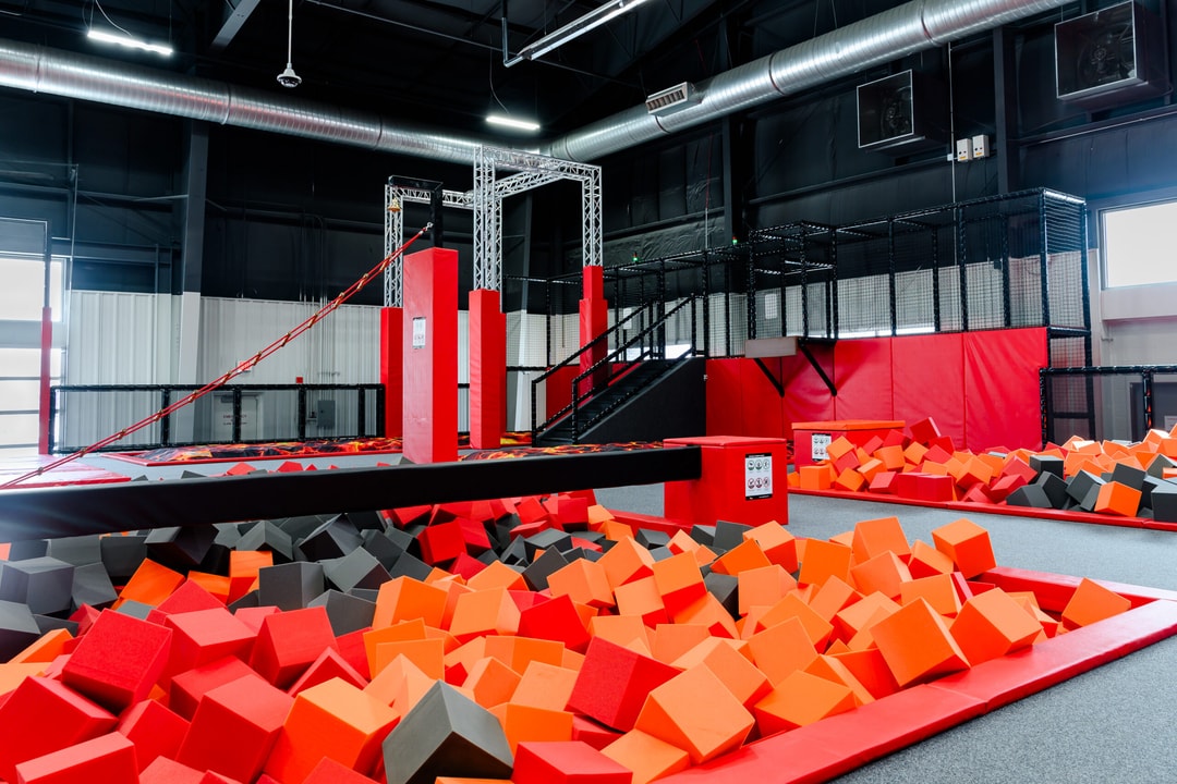 Balance beam, Jacob's ladder, and foam pit challenge area at Lava Island Billings.