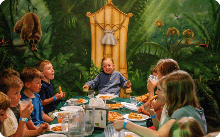 Kids celebrating in a jungle-themed party room at Lava Island.