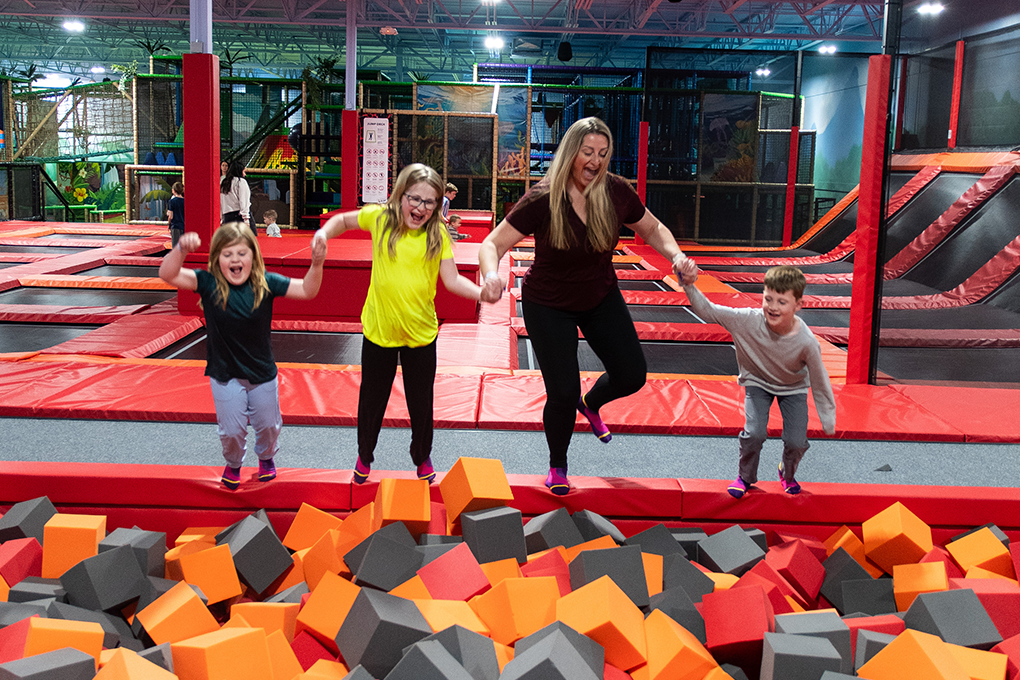 Family jumping near the foam pit at Lava Island Manchester.