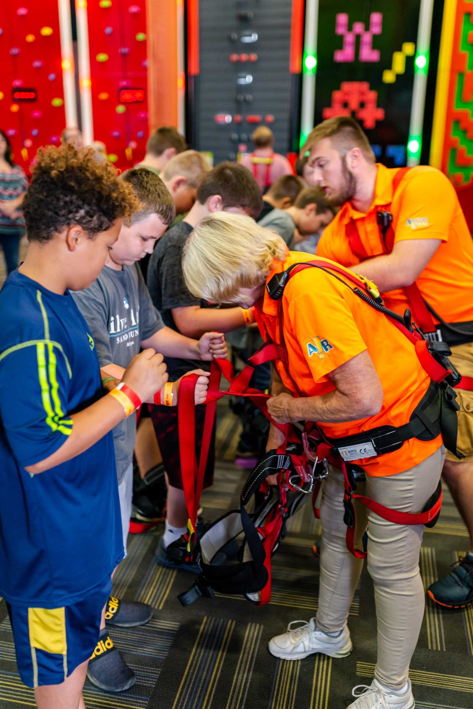 Staff helping kids into harnesses at LiggettVille Santa Fe