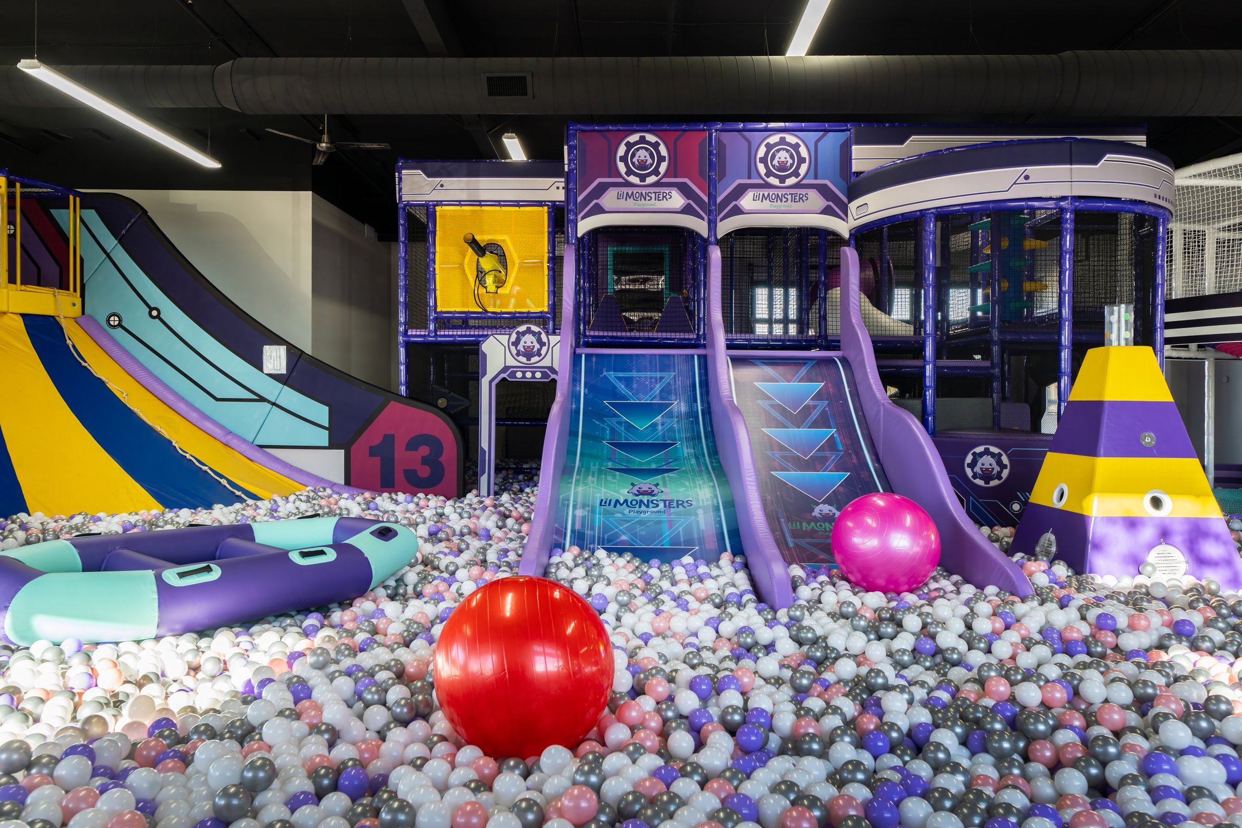Wide view of Lil Monsters Playground with ball pits and padded play equipment.