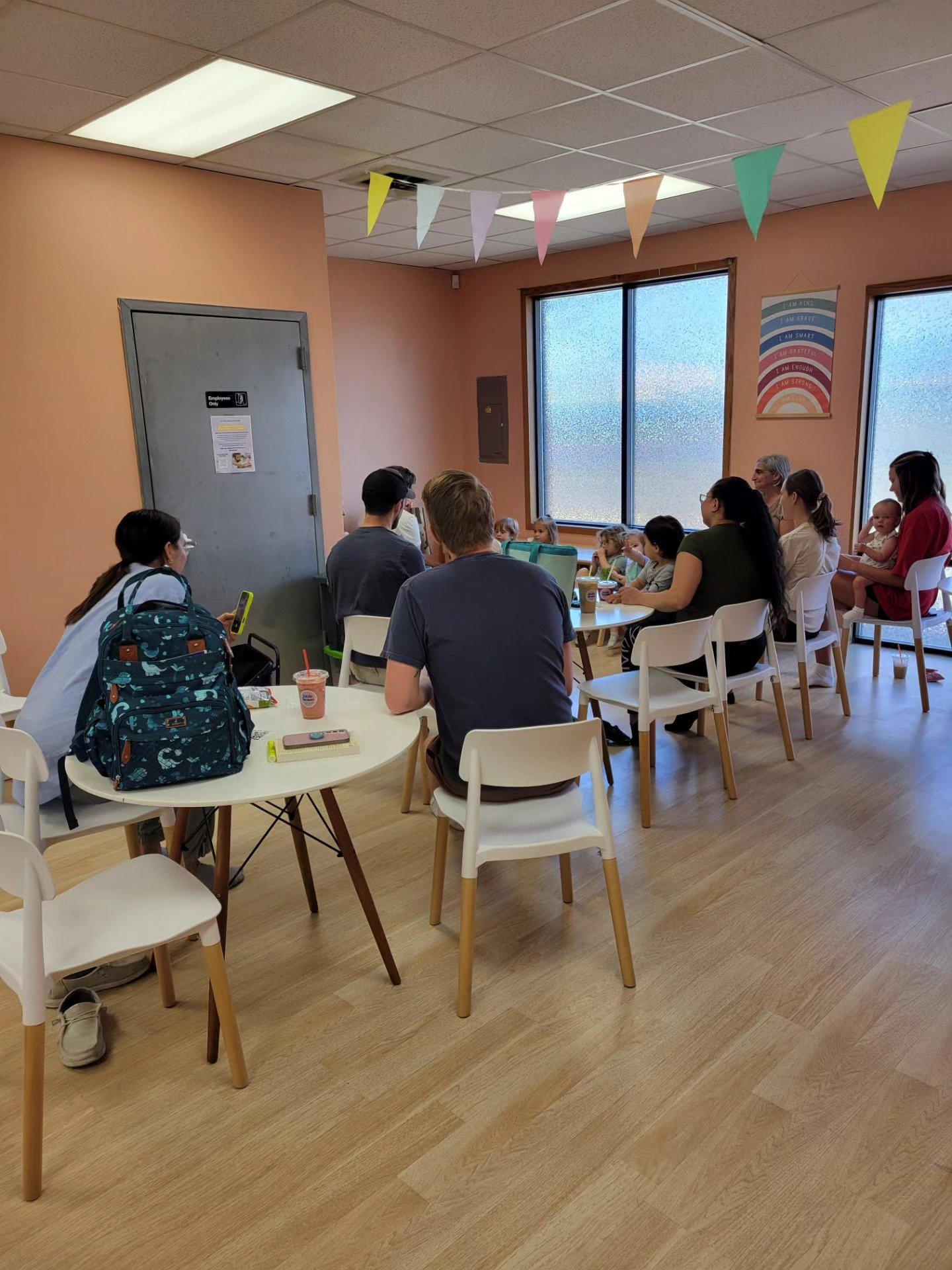 Tables and seating area for caregivers inside Little Beans Play Café.
