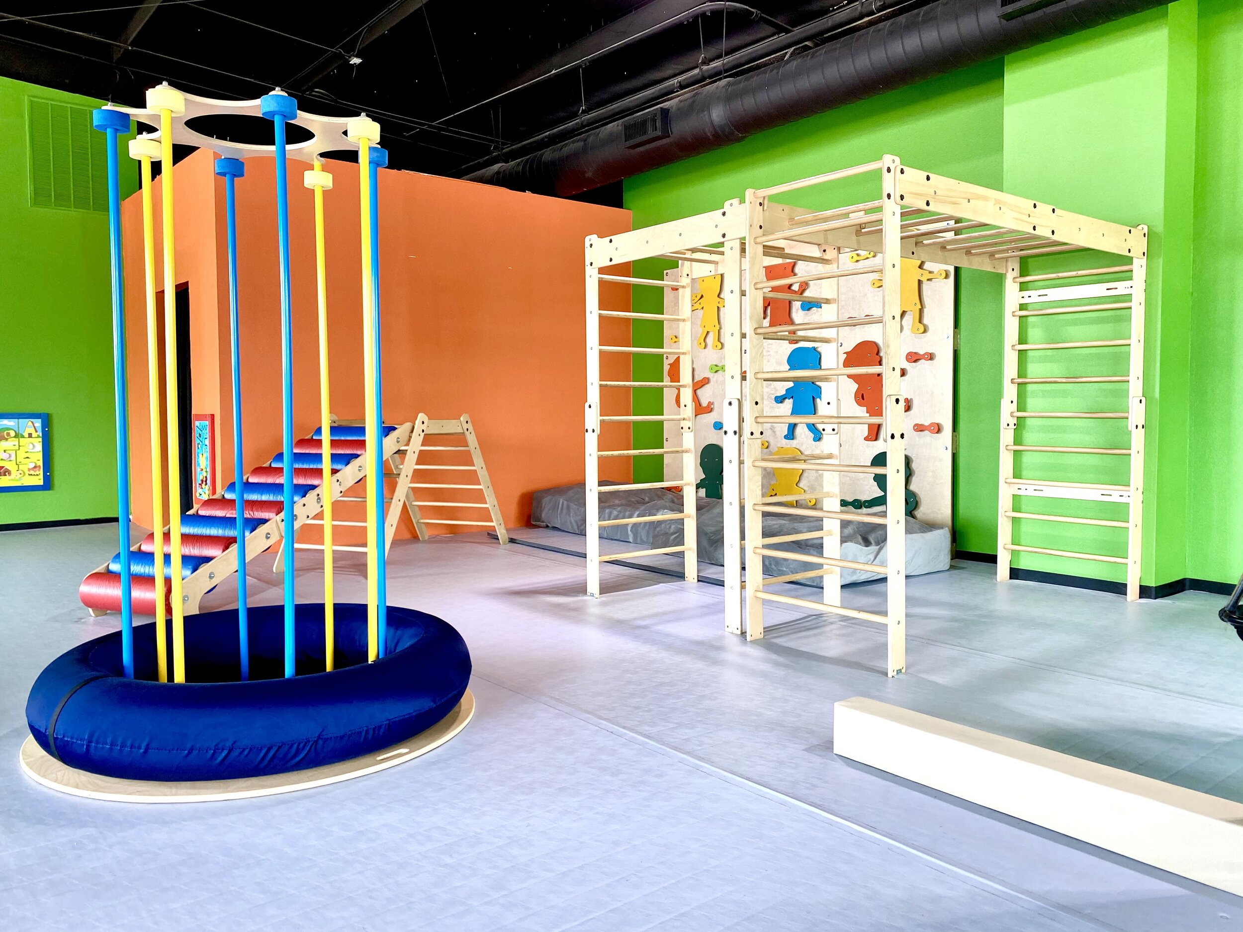 Climbing and movement area at Little Land Cedar Park with colorful gross-motor equipment.