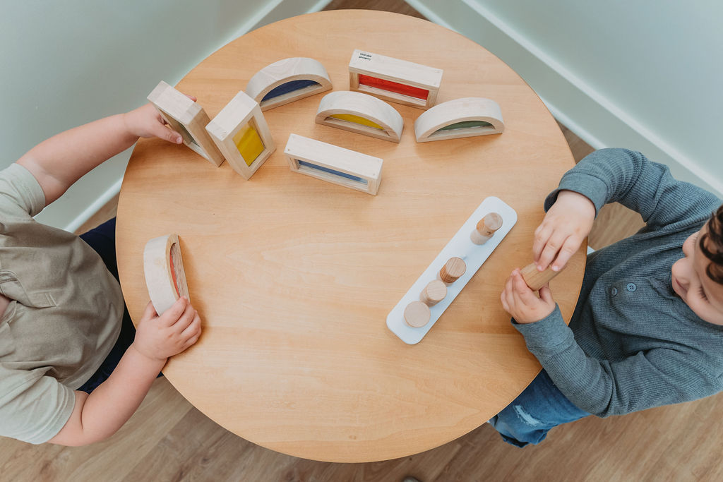 Kids using tabletop sensory and building materials at Little Roots.
