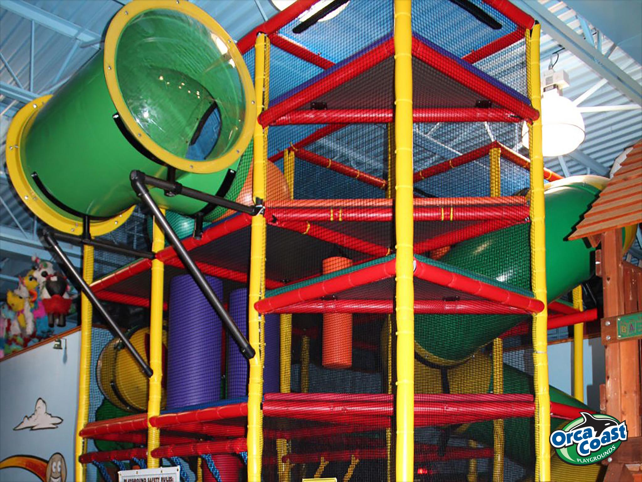 Tall indoor play structure with tube slides and climbing levels at Lost in Fun.
