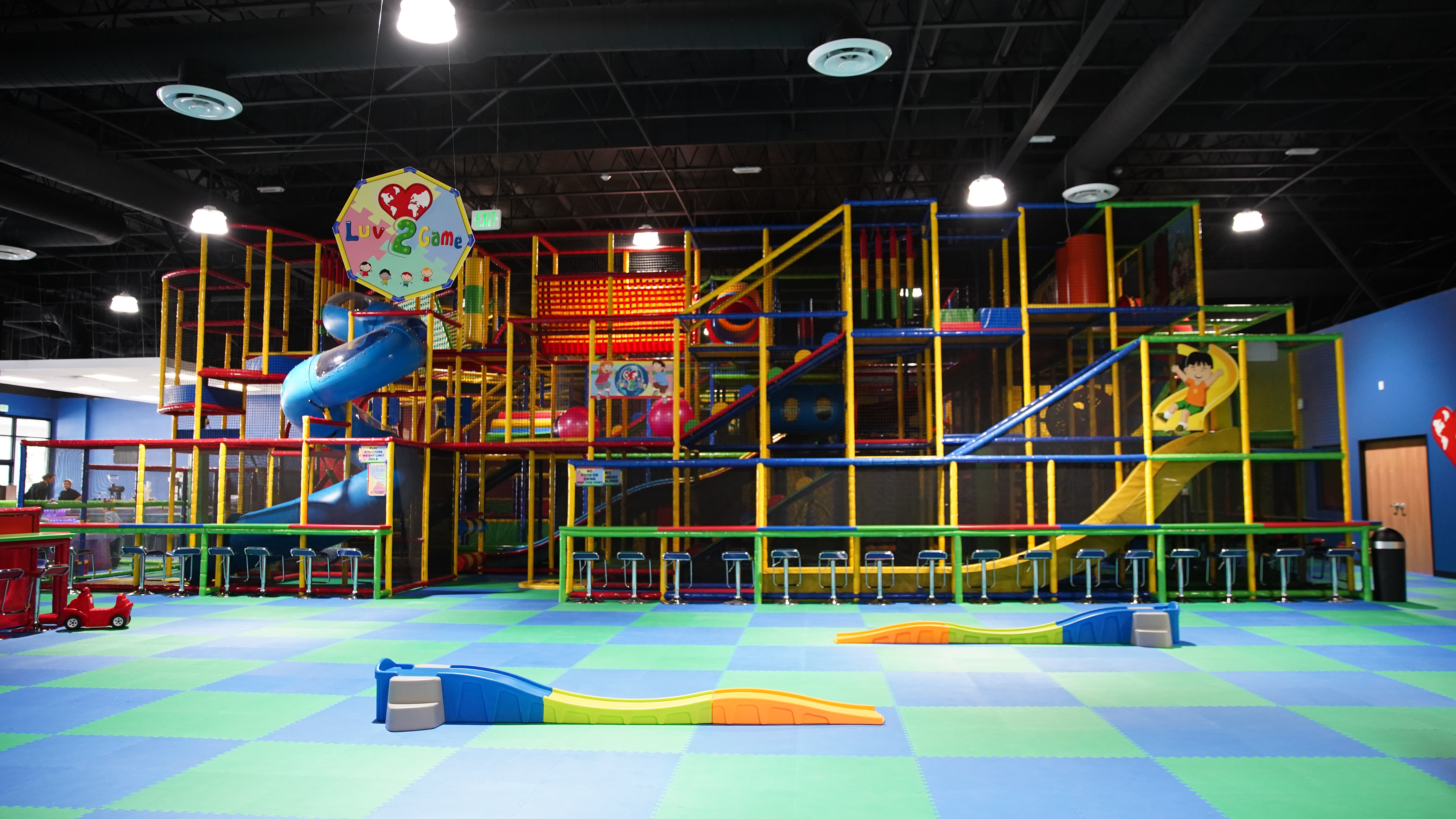 Multi-level indoor playground with bright climbing features at Luv 2 Play Riverside.