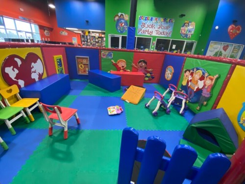 Contained toddler play area with padded flooring and low play pieces at Luv 2 Play Sutton