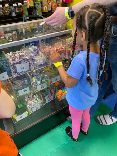 Child choosing prizes at the arcade redemption counter at Luv 2 Play Sutton