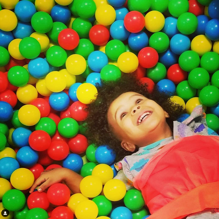 Child smiling in the ball pit at Millie Moo's Orlando.