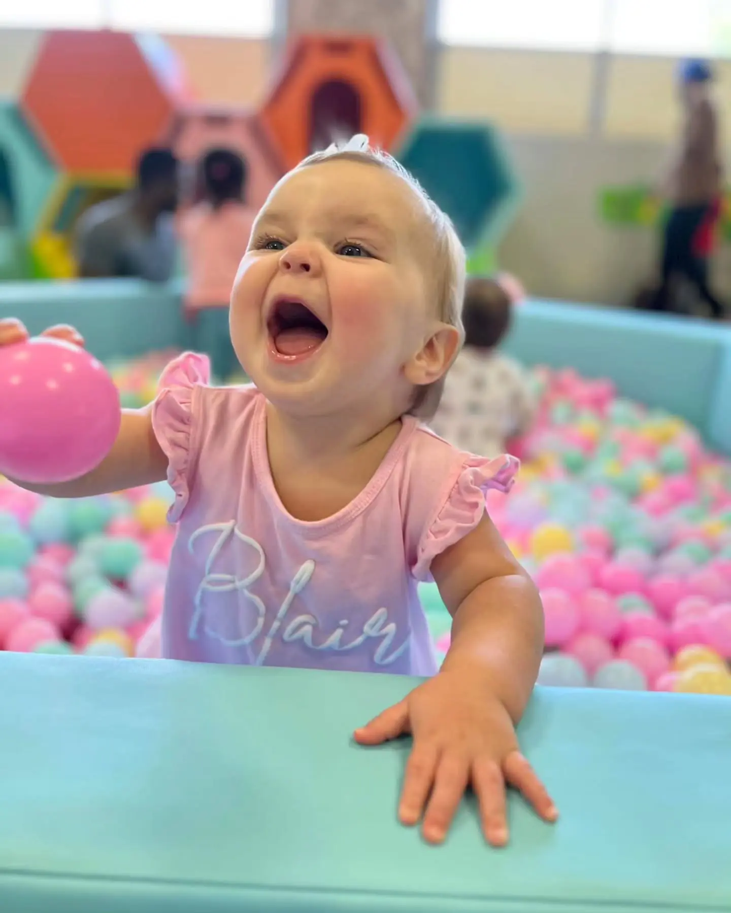 Young child playing in a pastel ball pit at Mochas & Minis.