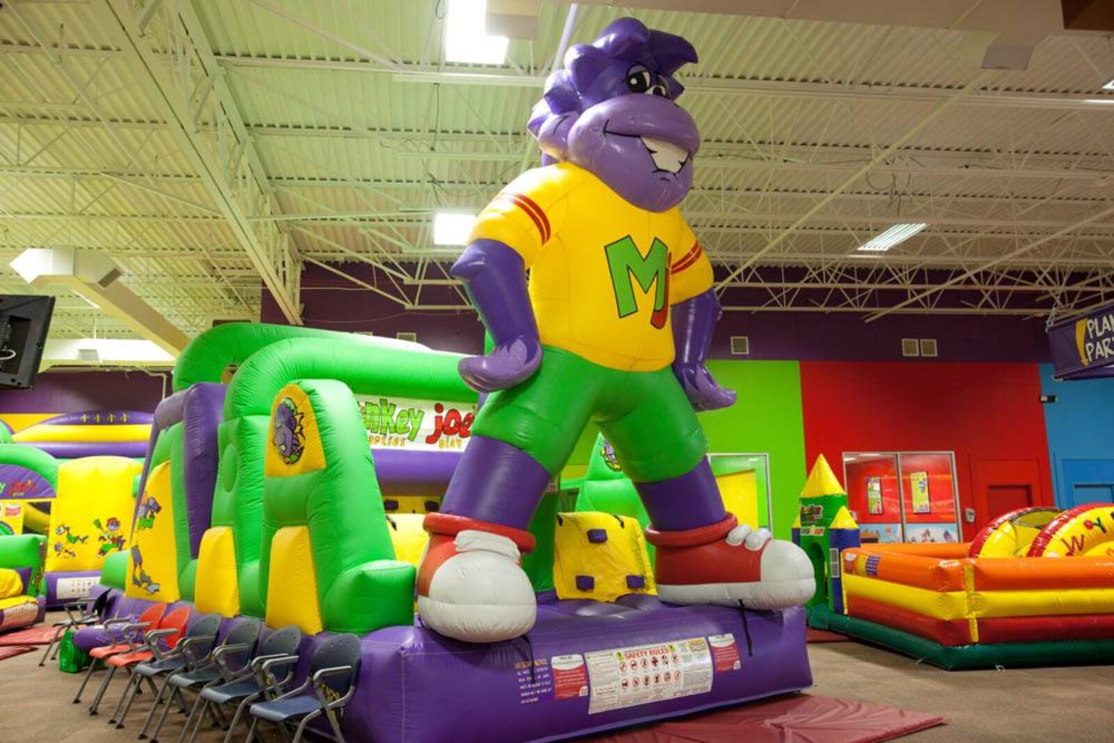 Children playing on bright indoor inflatable attractions at Monkey Joe's