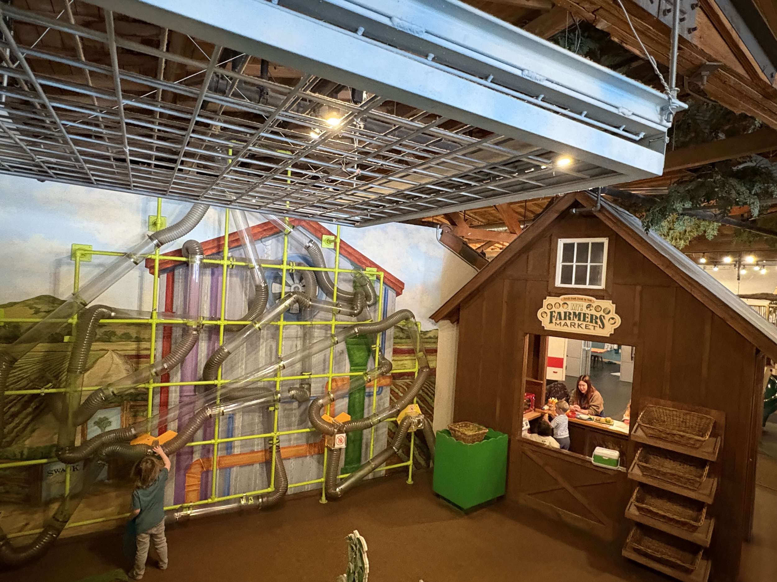 Children using the farmers market exhibit at MY Museum.