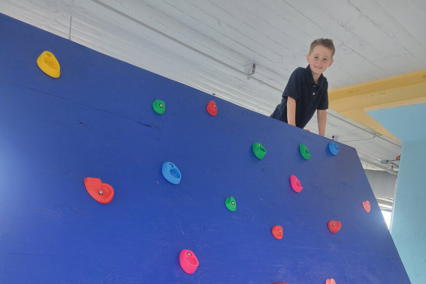Child climbing a wall at My World Discovery Museum