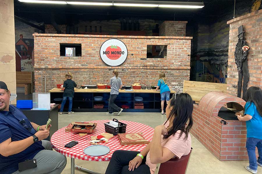 Kids using the play pizzeria exhibit at My World Discovery Museum