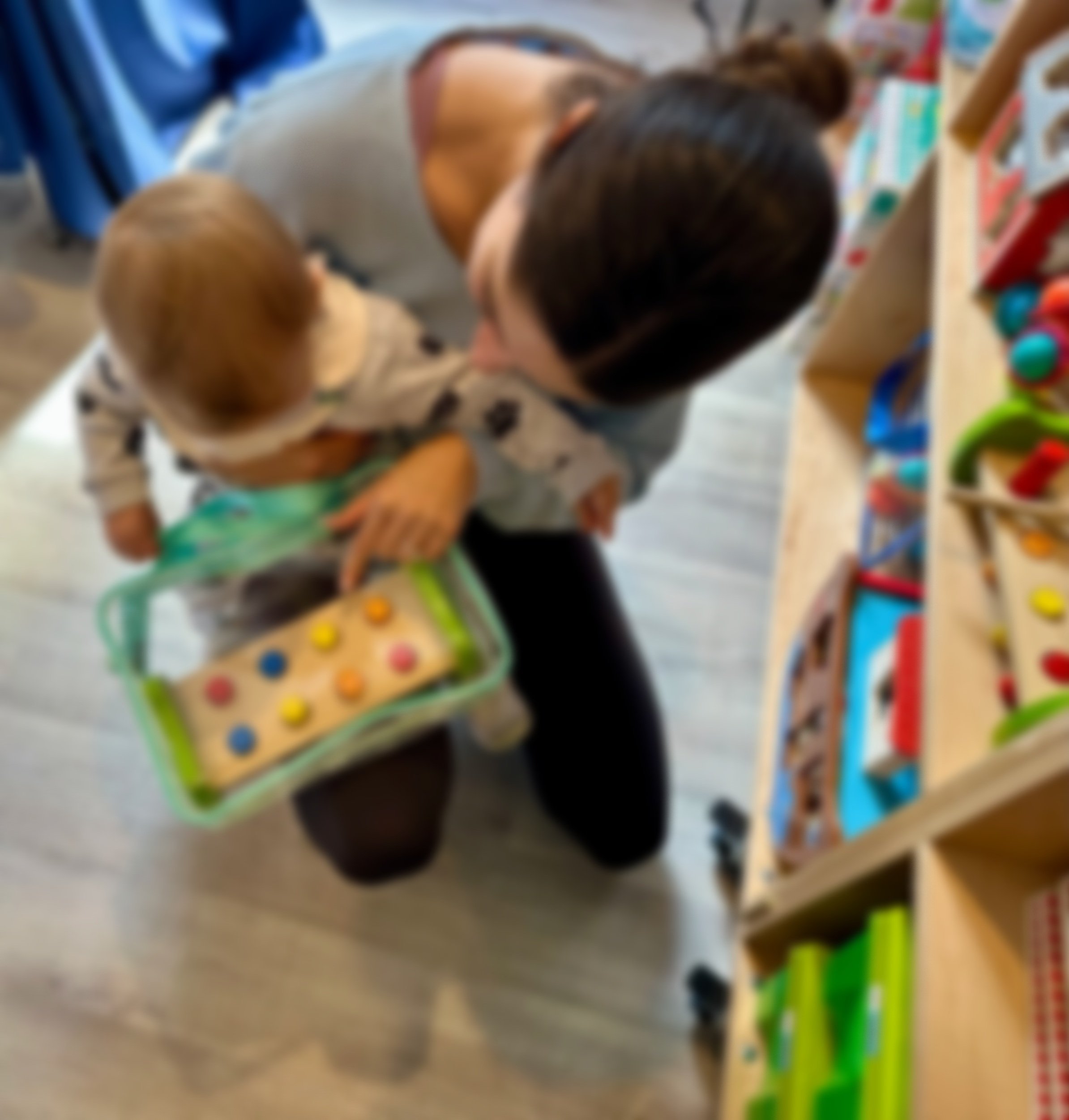 Caregiver and young child using the toy shelves inside Nantucket Toy Library.