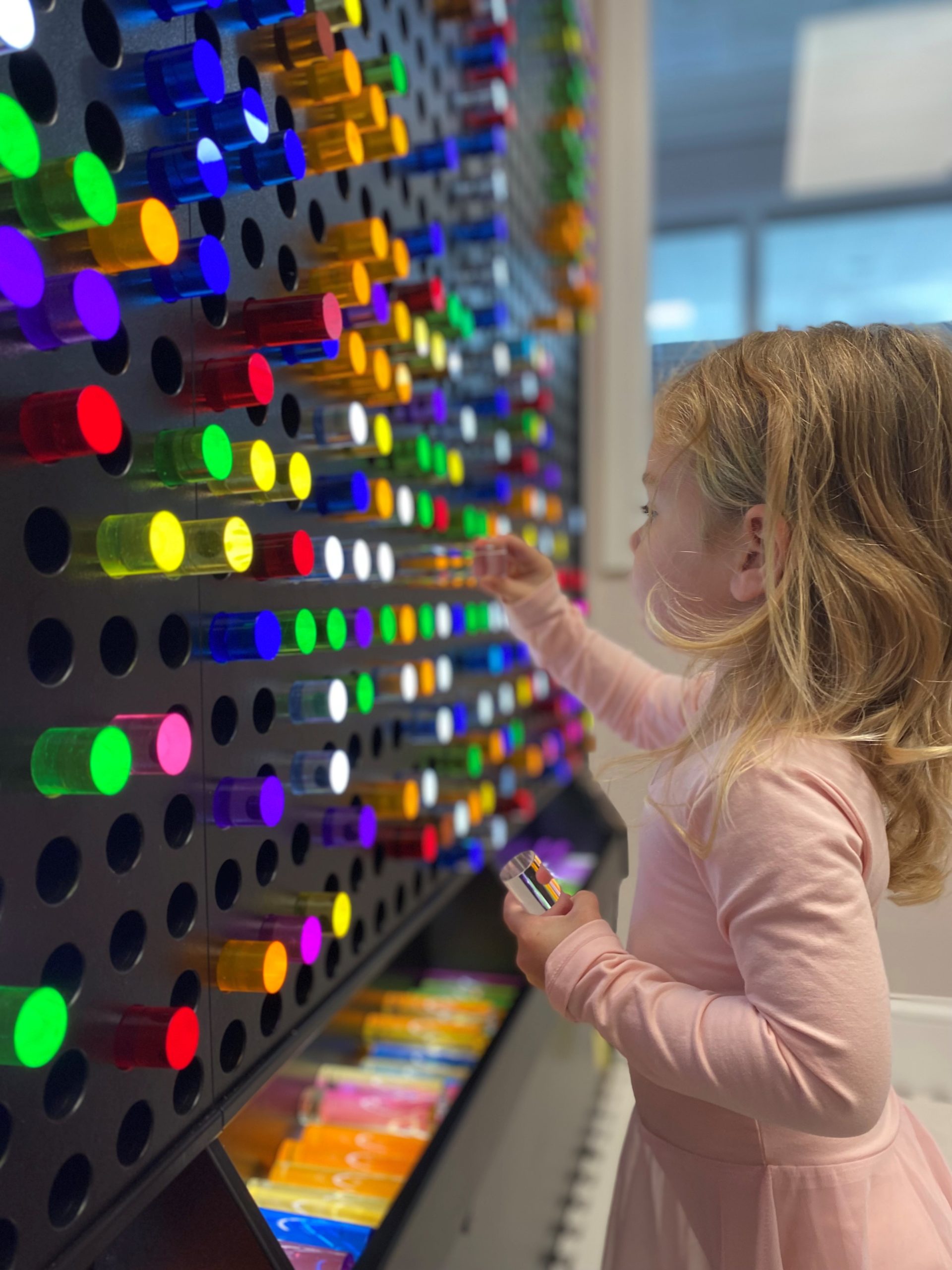 Child exploring a hands-on light exhibit at North Shore Children's Museum