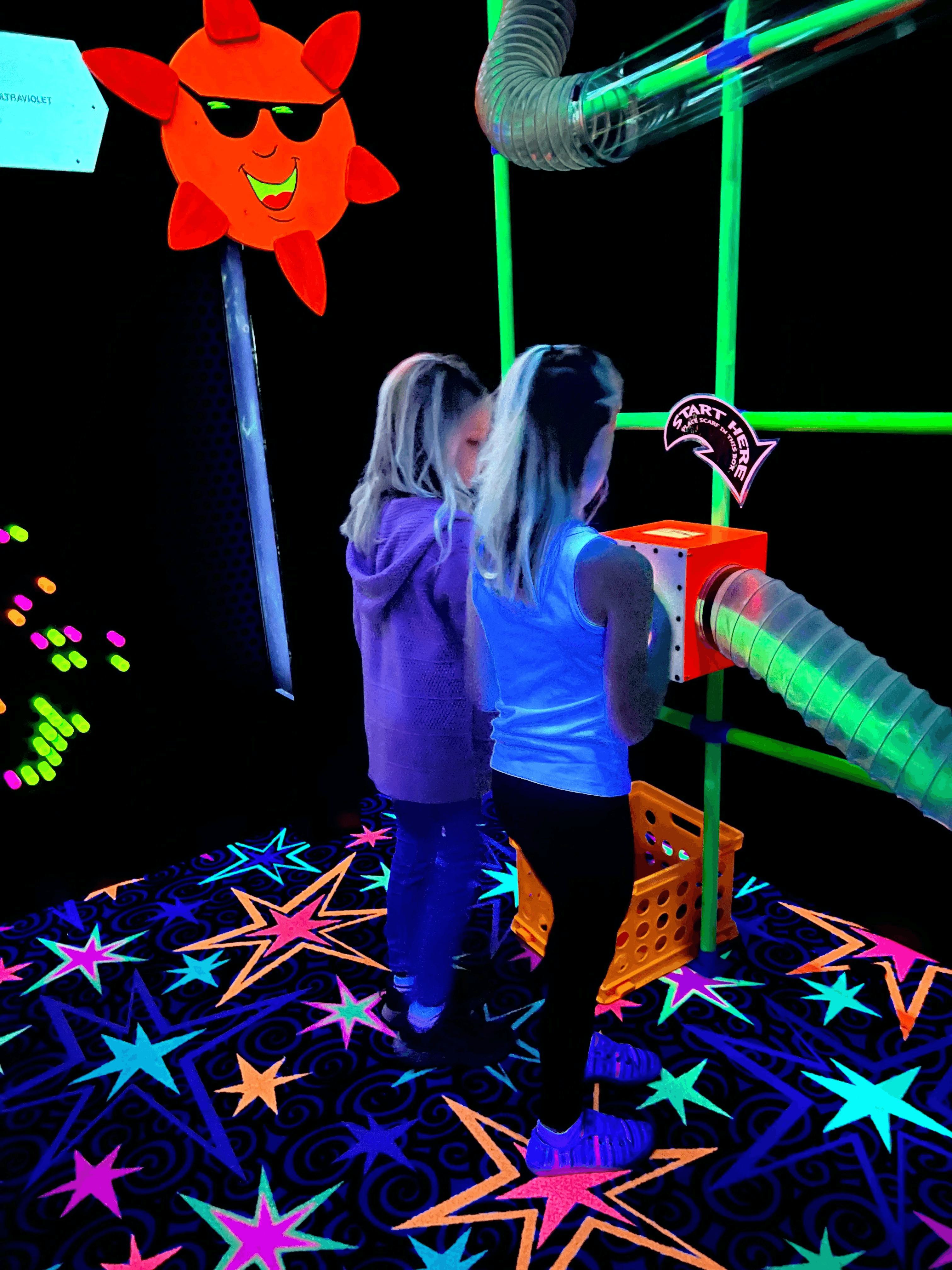 Children exploring the blacklight Energy Expedition exhibit at Northwoods Children's Museum
