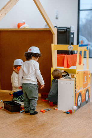Children playing in a construction-themed corner at Nurture To Play.