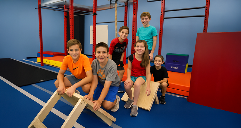 Kids using ninja-style obstacles at Obstacle Arena.