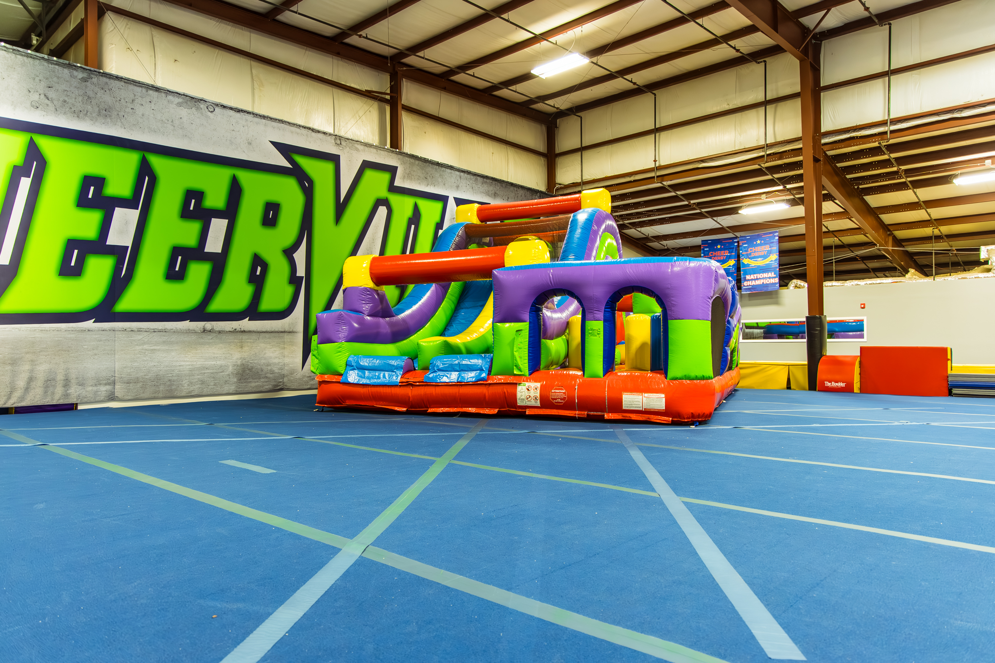Indoor party arena at Party Place at CheerVille with large open space and play equipment.