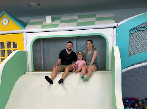 Wide indoor soft-play slide at Peachy Playtown.