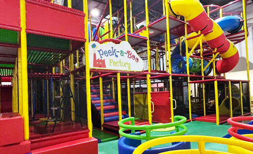 Closer view of the climbing structure and slide entry at Peek-a-Boo Factory