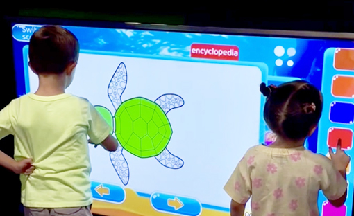 Children using an interactive digital play wall at Peek-a-Boo Factory