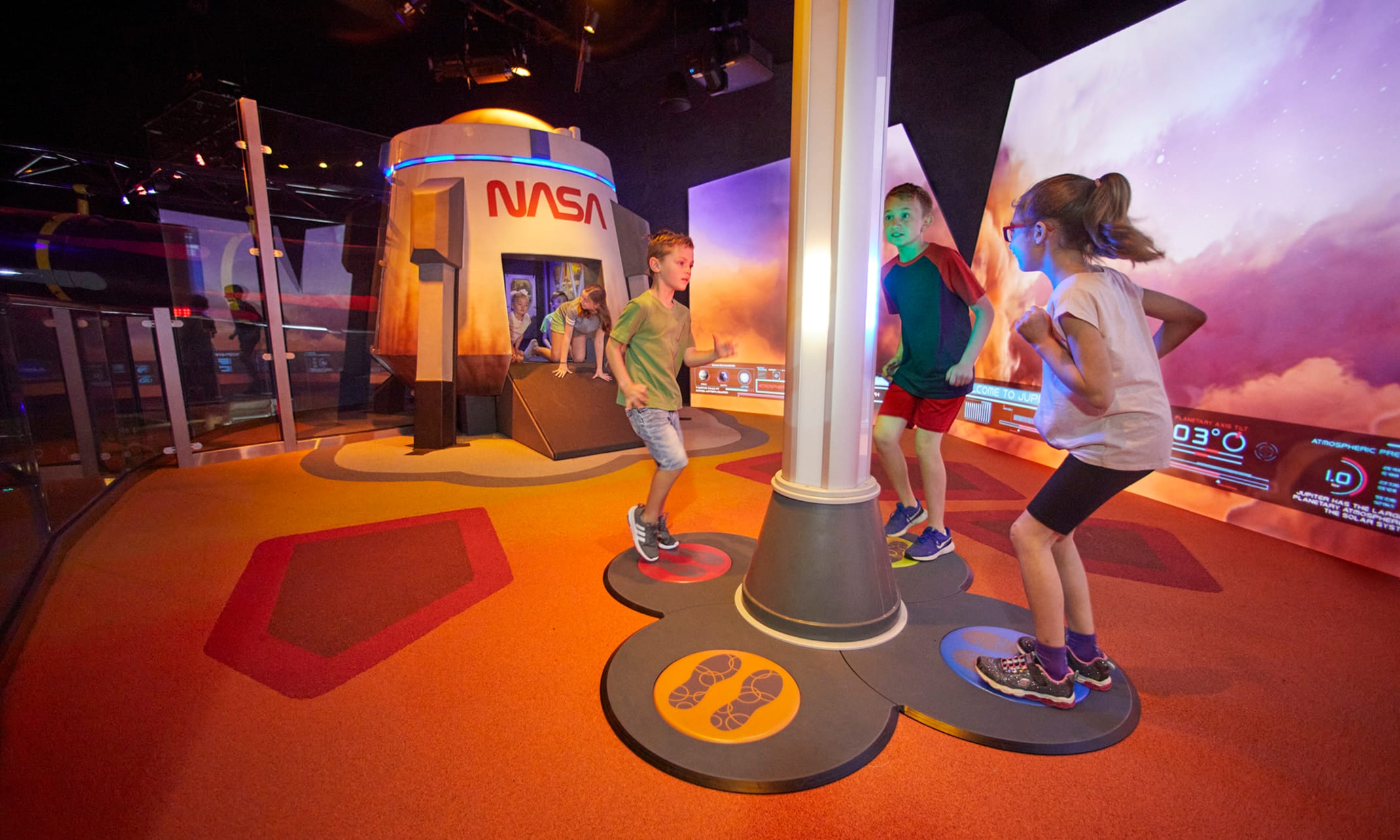 Children using the interactive play and learning area inside Planet Play.
