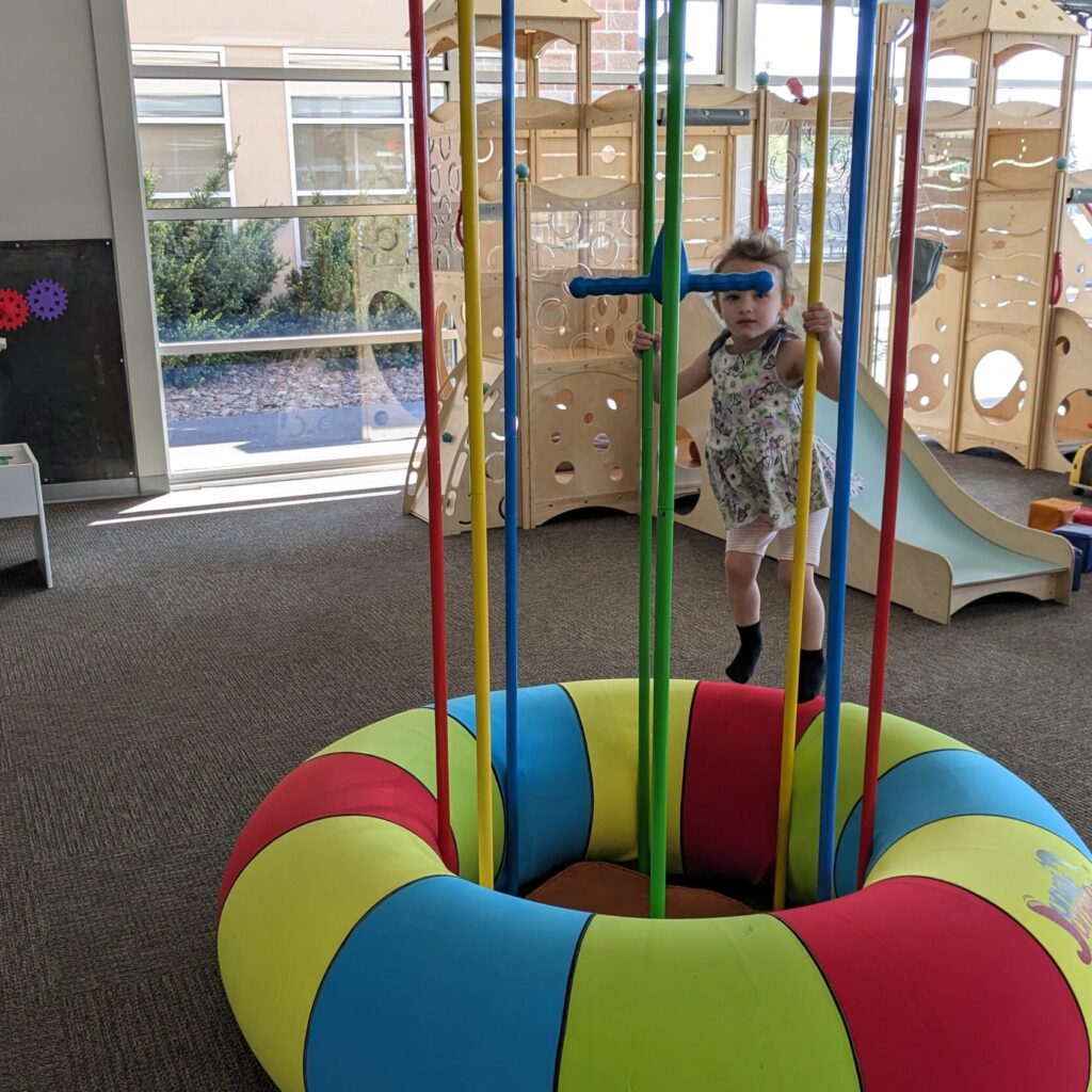 Child using the hanging ring feature at Play/Cafe in Yakima.