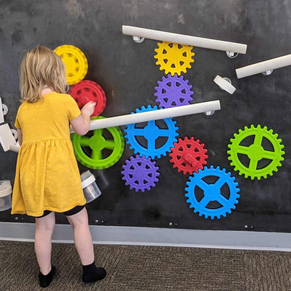 Wall-mounted sensory gears at Play/Cafe in Yakima.